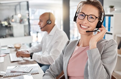 Frau mit Headset lächelt in Kamera